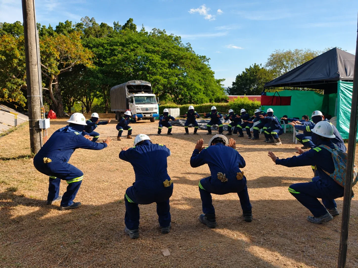 Equipo de trabajo realizando ejercicios de calentamiento antes de iniciar la jornada laboral